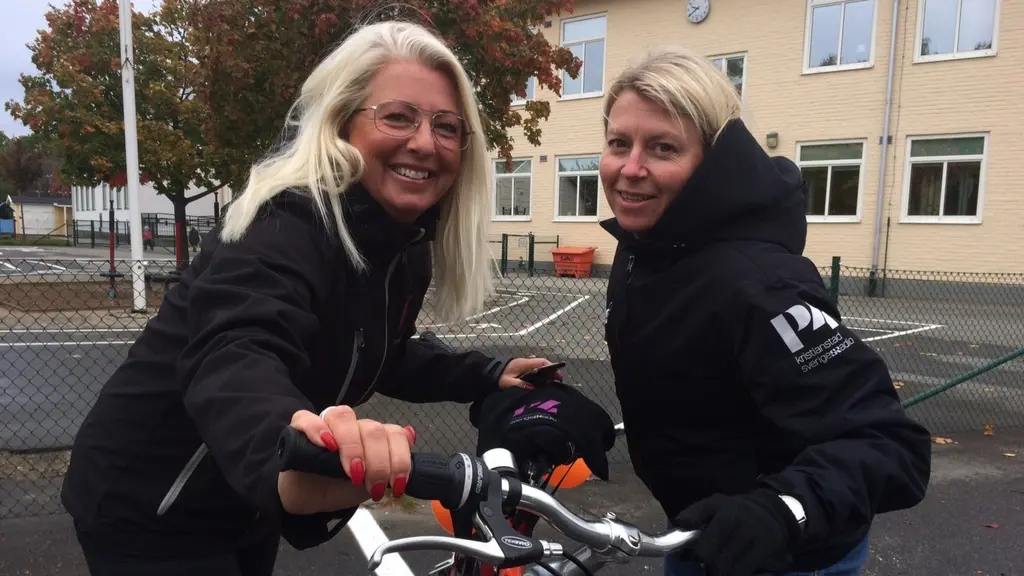 Två blonda kvinnor vid en cykel