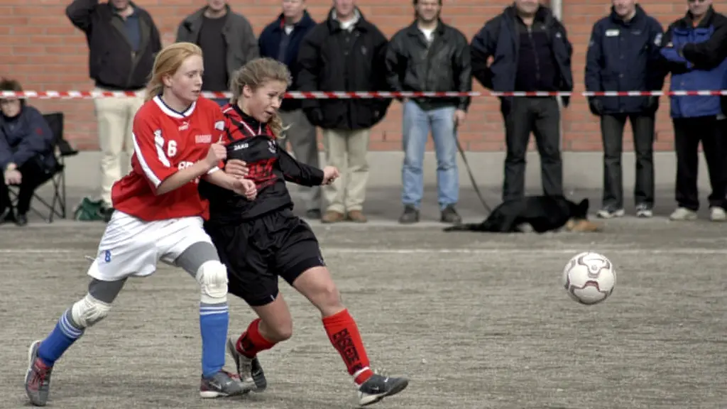 Två tjejer spelar fotboll.