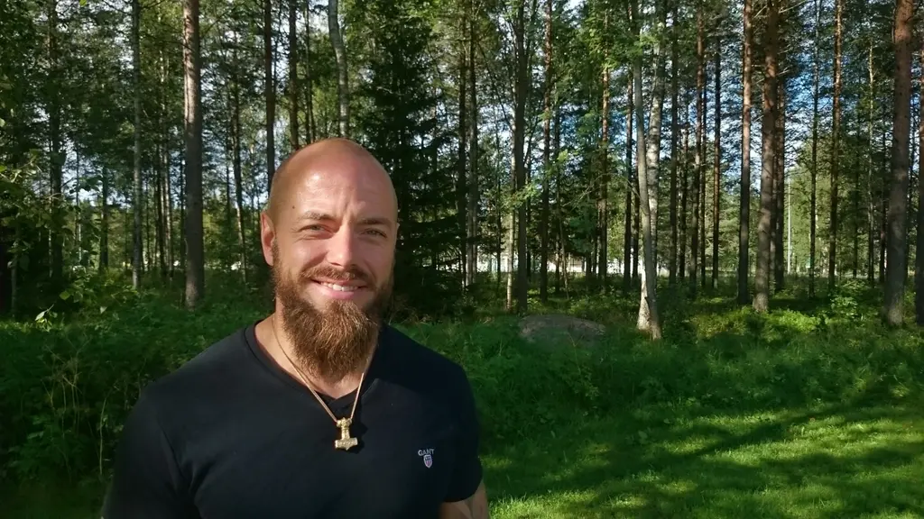 Simon Åström cyklist står i solen och ler.