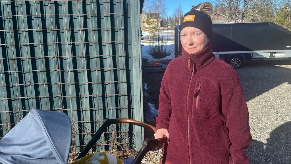 Stina Dahlström, som fick  åka över 20 mil när BB i Lycksele stängde, står utomhus och drar en barnvagn.