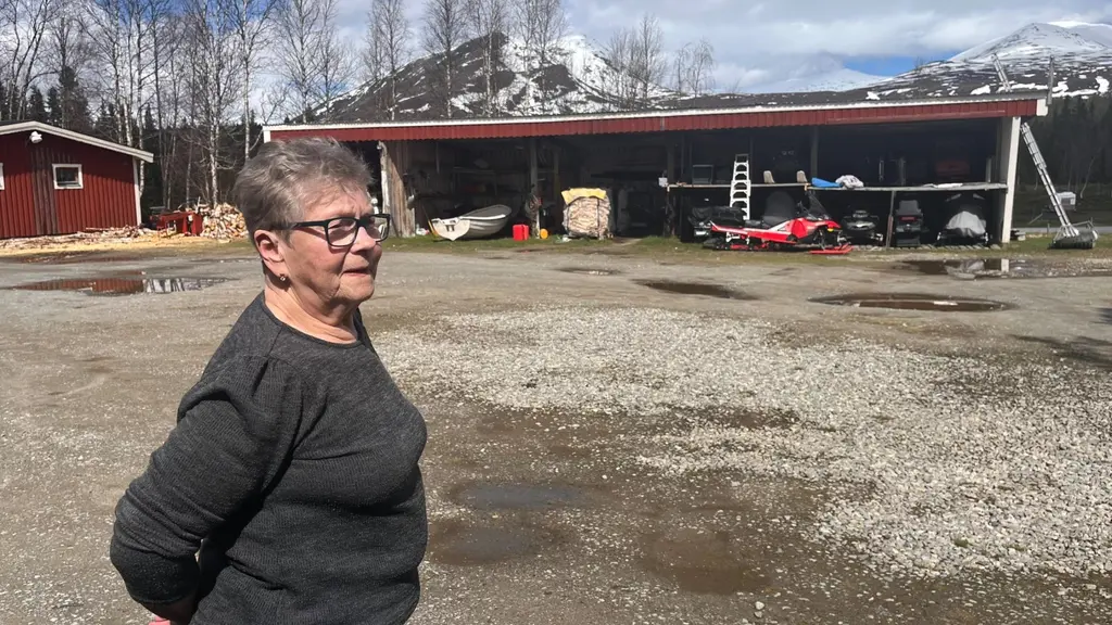 Birgit Isaksson står på gård med fjäll i bakgrunden.