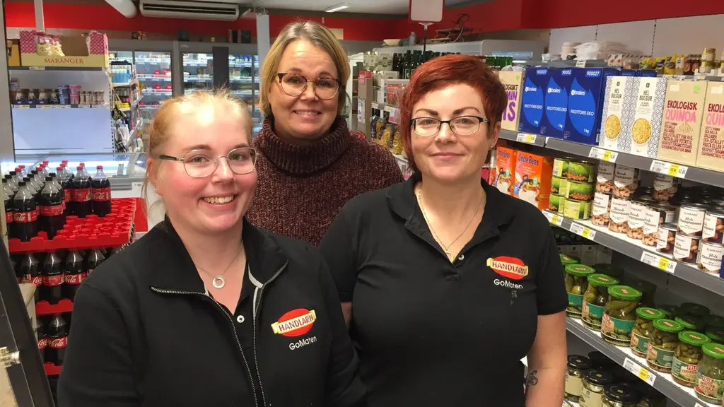 Tre kvinnor som i butik. Alla glada, i 40-årsåldern, har glasögon och jobbar här.