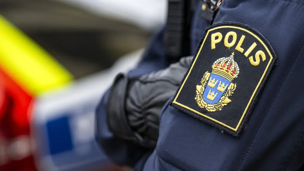 En polis i uniform syns nära ett misstänkt farligt föremål på Carl Krooks gata i Helsingborg. I bakgrunden skymtar en polisbil med blåljus. Händelsen har lett till insatser på plats.