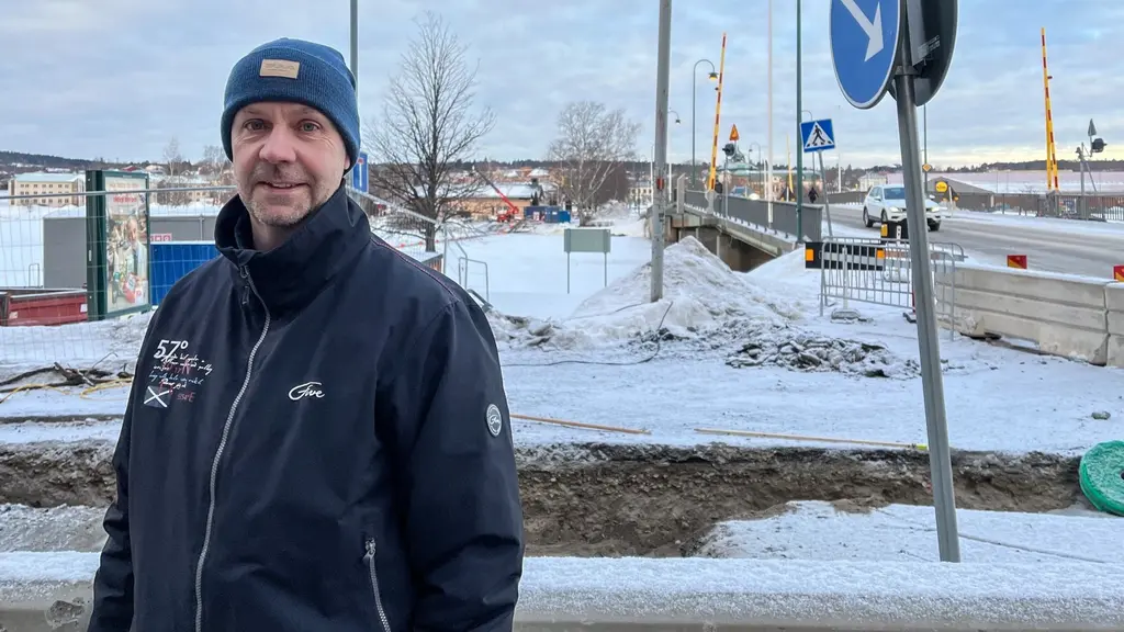Thomas Jensen, chef för samhällsförvaltningen i Härnösands kommun, står utomhus framför en snötäckt stadsmiljö med en bro och trafikskyltar synliga i bakgrunden.