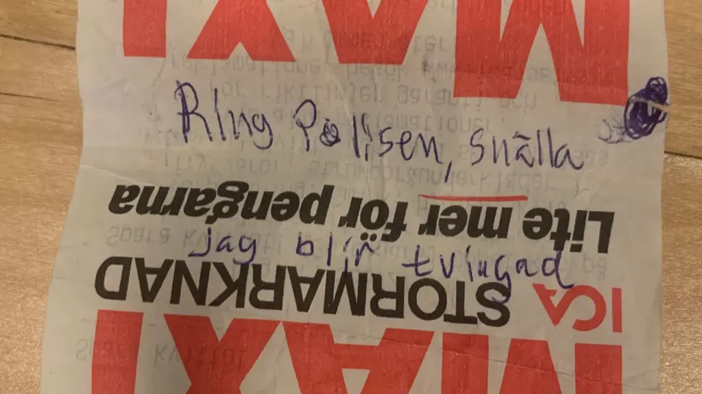 Ett handskrivet meddelande på ett kvitto från en matbutik. Texten ber om hjälp och uppmanar att kontakta polisen. Kvitto bakgrunden har butikens logotyp och reklamtryck.
