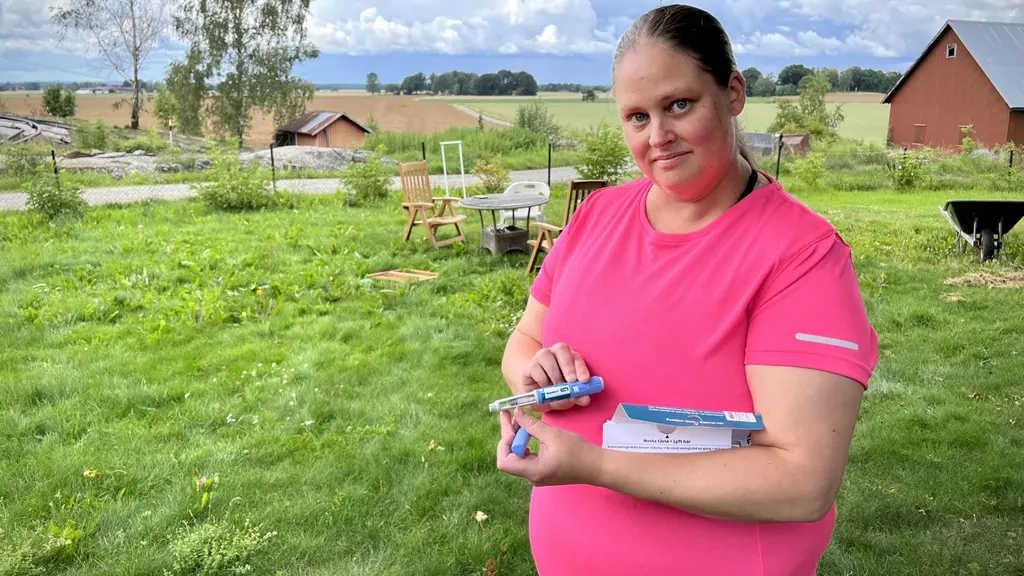 En kvinna som står i lantlig miljö.