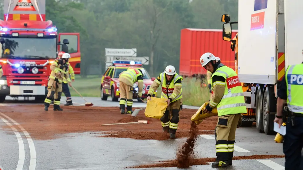 Bild från en trafikolycka där diesel läckt ut på vägområdet. Räddningstjänsten häller ut absorberande pulver på vägen. Foto: Johan Nilsson / TT
