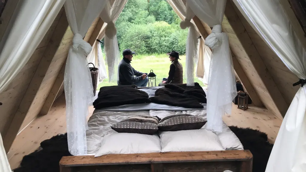 Två personer sitter i ett möblerat tält.
