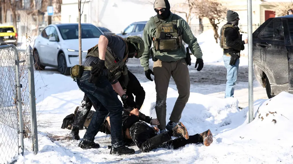 Migrationspoliser griper en man i Minneapolis, mannen ligger på en snöig gata.