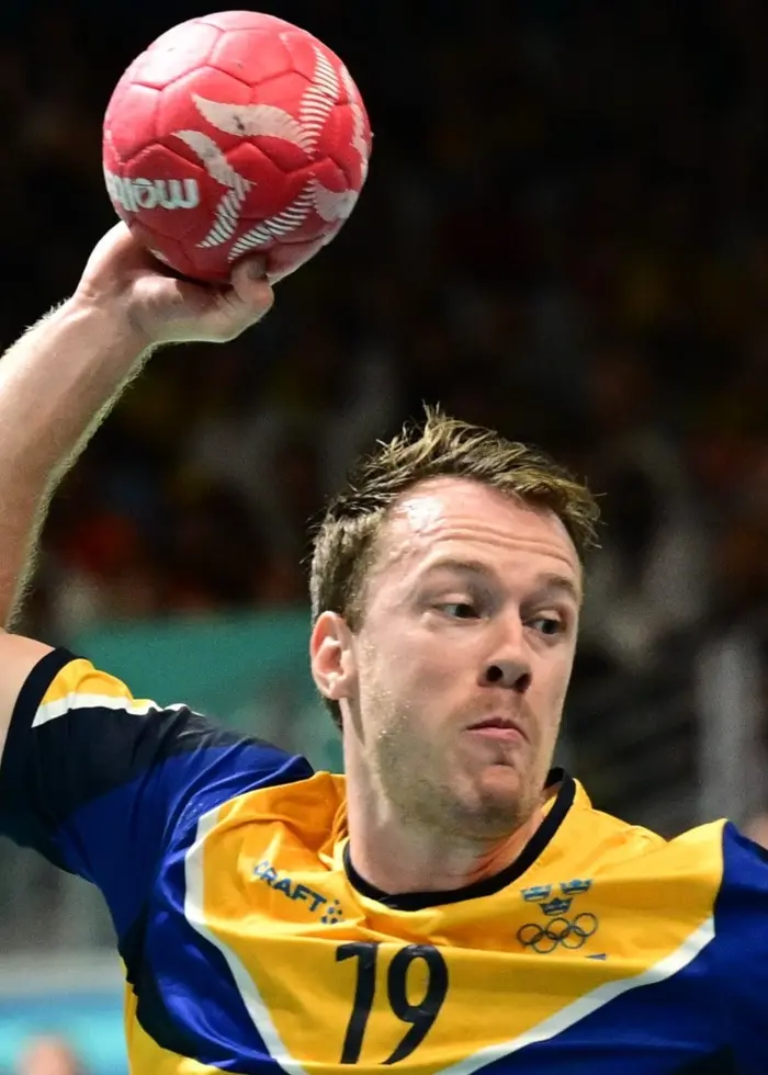 Svenska handbollsspelaren Felix Claar i gul-blå landslagströja hoppar och skjuter bollen under en match i grupp A mot Slovenien i South Paris Arena under sommar-OS 2024 i Paris.