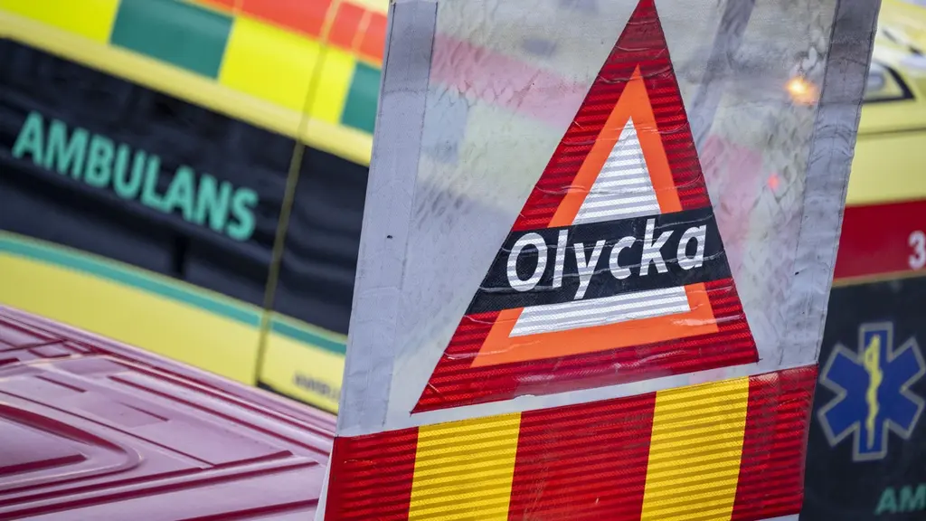 En trafikolycka med en buss från Skånetrafiken som kört in i en bropelare på E22 Stockholmsvägen i Malmö. På bilden syns en varningsskylt med texten 'Olycka' samt ambulansfordon i bakgrunden.