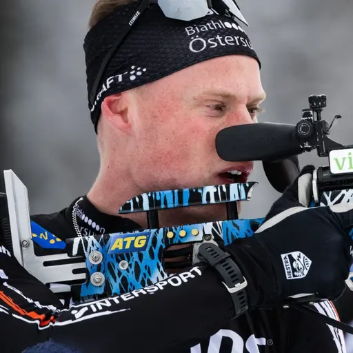 Henning Sjökvist med sitt skidskyttegevär lyft framför ansiktet.