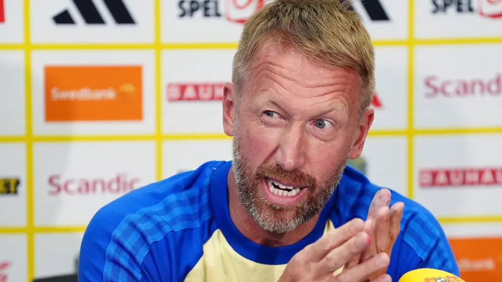 Sveriges förbundskapten Graham Potter under en pressträff i fotbolls-VM, framför en sponsorvägg och mikrofoner.