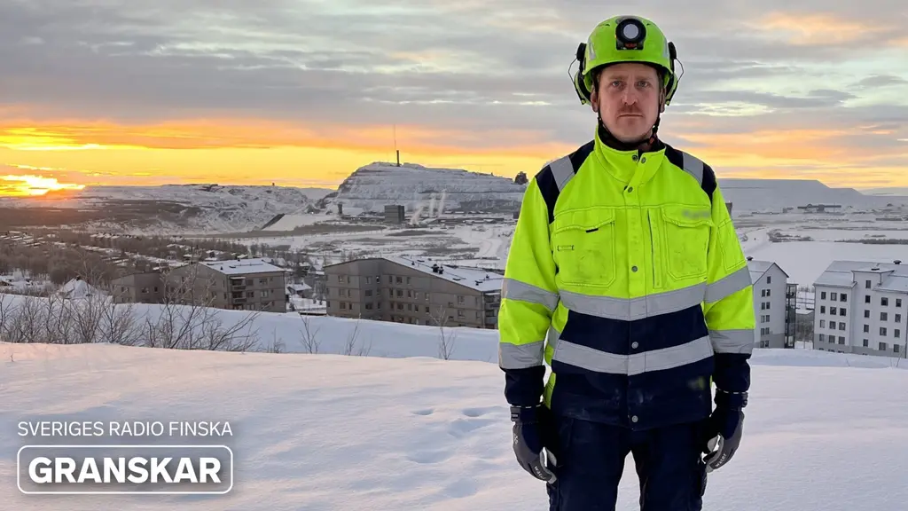 Tuomo Saarensilta i skyddsutrustning står framför ett snötäckt landskap med byggnader och en kulle i bakgrunden. Solnedgången färgar himlen orange och gult. Texten ' Sveriges Radio Finska Granskar' syns i bilden.