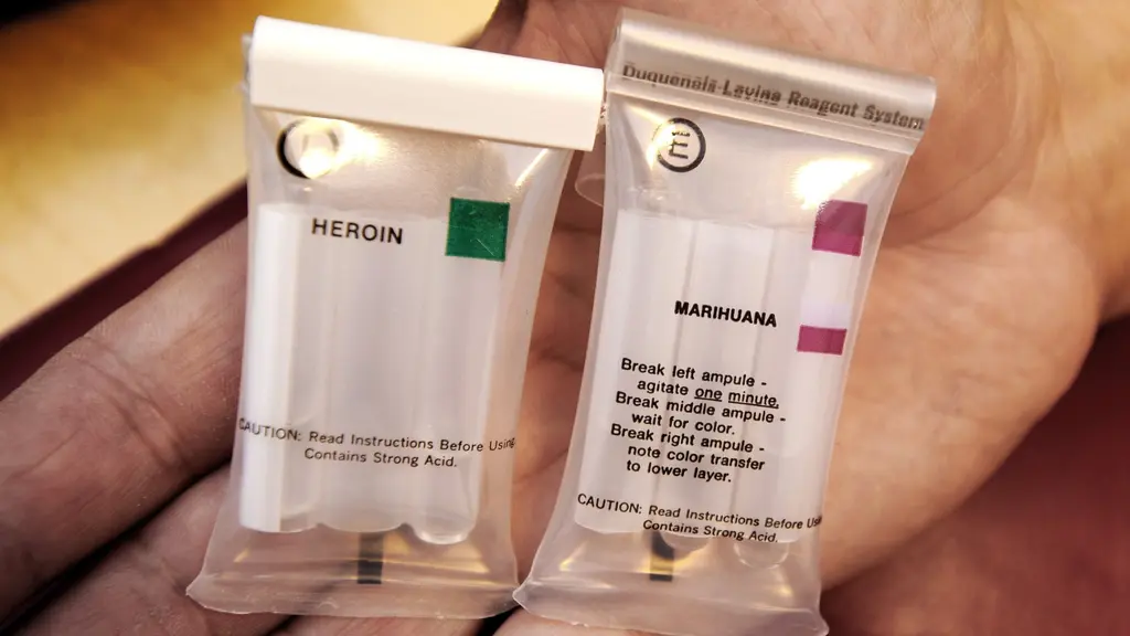 Hand holding two drug tests.