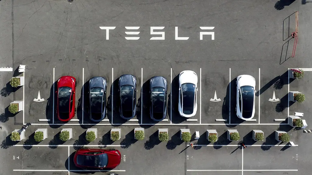 Parked Tesla cars in various colors seen from above. 