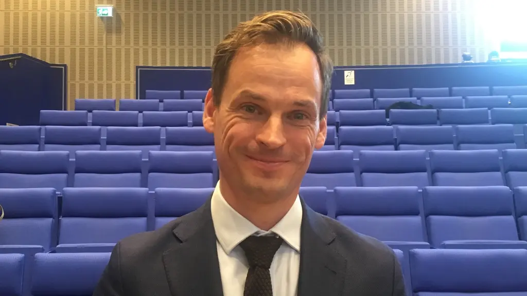 person smiling in front of rows of seats