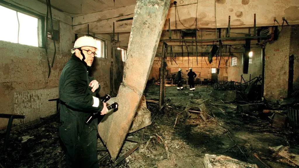 A firefighter in a burnt out room.