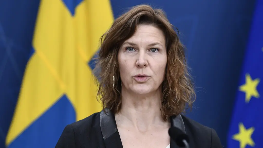 A woman standing in front of a swedish flag.