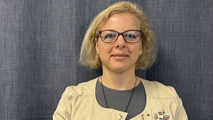 Malin Langenfors, chef på Länstyrelsen i Stockholm för enheten för nationelal minoriteter. närbild ljushårig kvinna med glasögon. Hon har små pins med flaggorna av de fem nationella minoriteterna fästa på sin jacka.