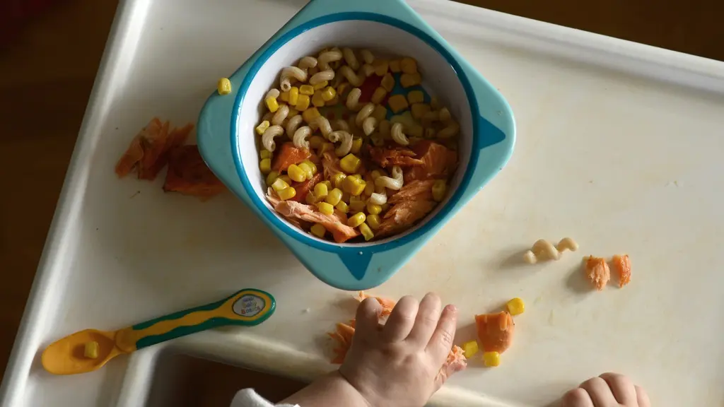 En bebis äter lunch med händerna