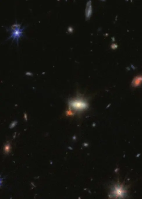 En bild av rymden med flera stjärnor och galaxer i olika färger och ljusstyrkor, inklusive röda prickar som kan indikera tidiga svarta hål. Bilden är tagen av James Webb-teleskopet.