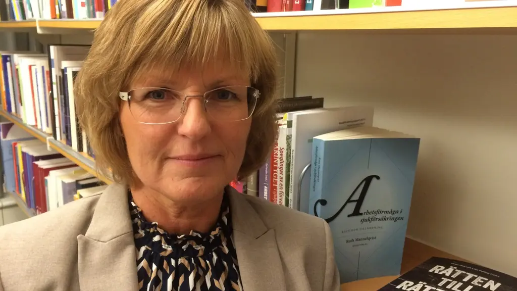 Ruth Mannelqvist framför bokhyllorna på sitt arbetsrum på Umeå Universitet.