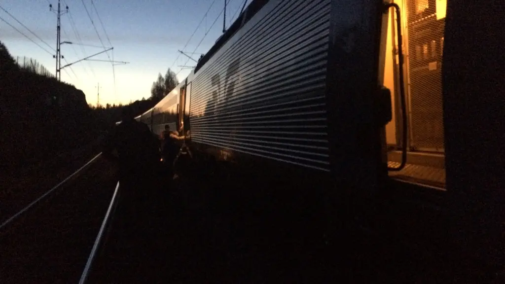 ett tåg står stilla på en räls i soluppgången 