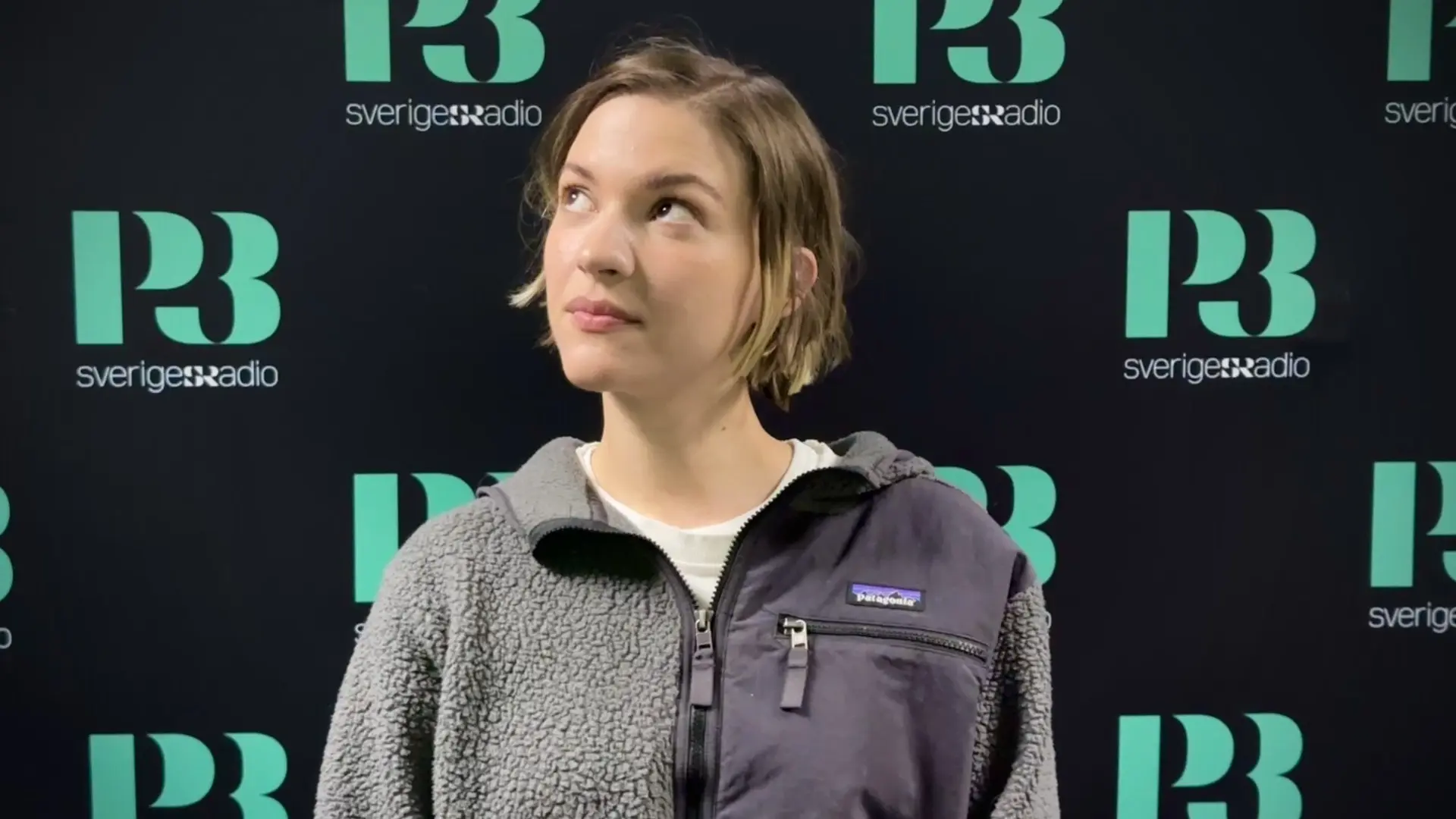 Artisten Tove Styrke står framför en svart skärm med p3 logotyp. 