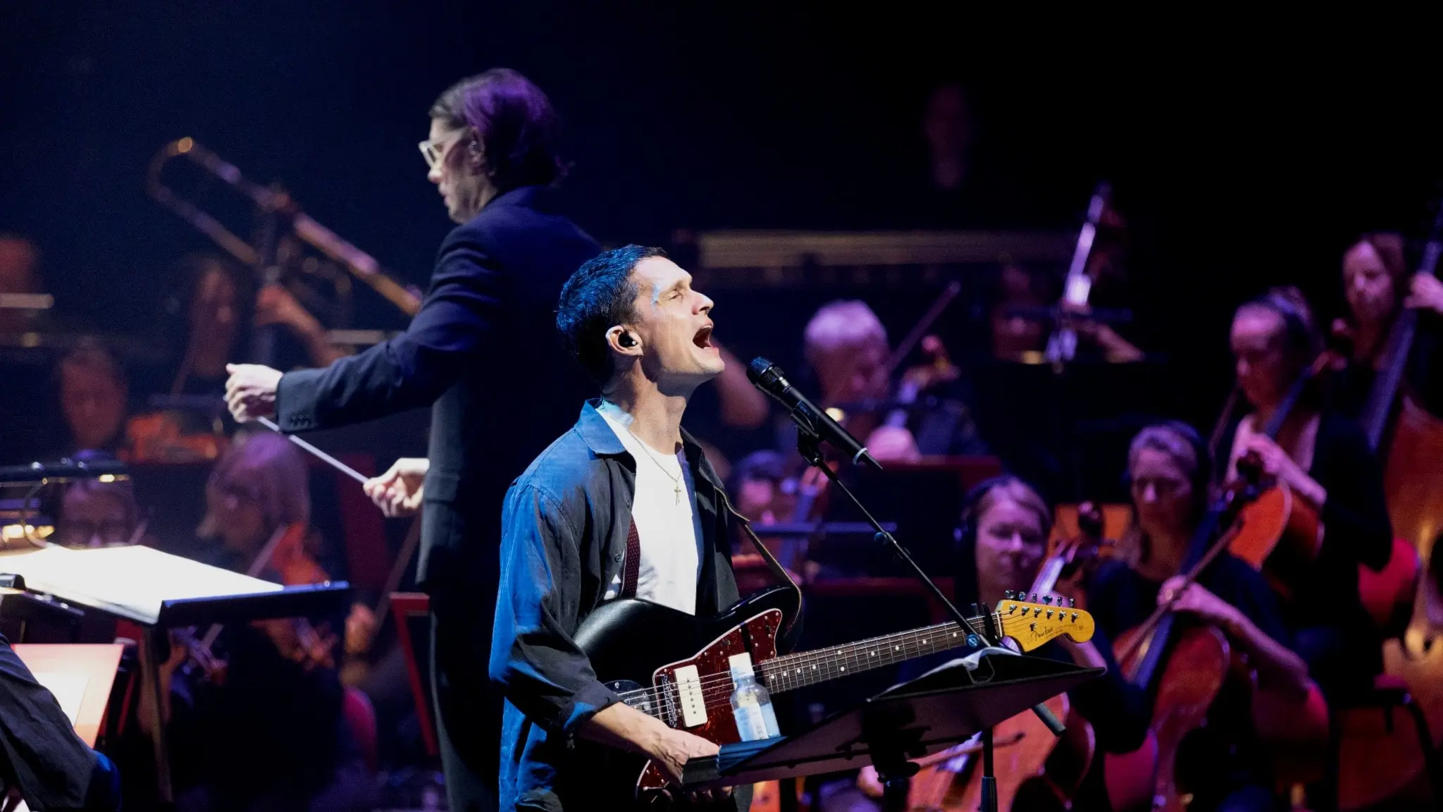 Jonathan Johansson, med elgitarren på magen, sjunger framför Sveriges Radios Symfoniorkester och dirigent Erik Arvinder.