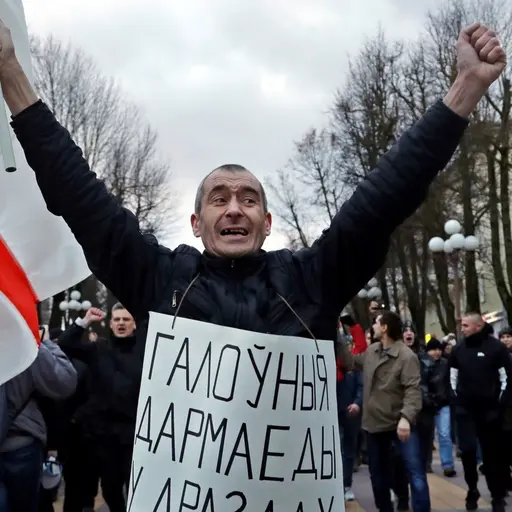 "De största parasiterna finns i Drozdy (presidentens bostad)" står det på mannens plakat. Fredagens demonstrationer i Maladzyechna, Belarus handlar om den två år gamla lagen om att människor som varit arbetslösa i mer än sex månader måste betala straffavgifter.