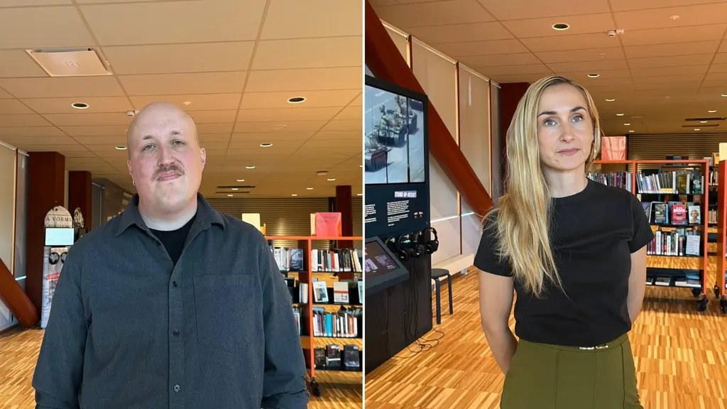 Två personer står i ett bibliotek under kampanjen 'Banned Books Week', omgivna av bokhyllor och skyltar som framhäver vikten av yttrandefrihet och läsning av förbjudna böcker.