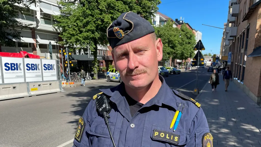Viktor Adolphson, områdespolisen Södermalm, står i polisuniform på en stadsgata i Stockholm.