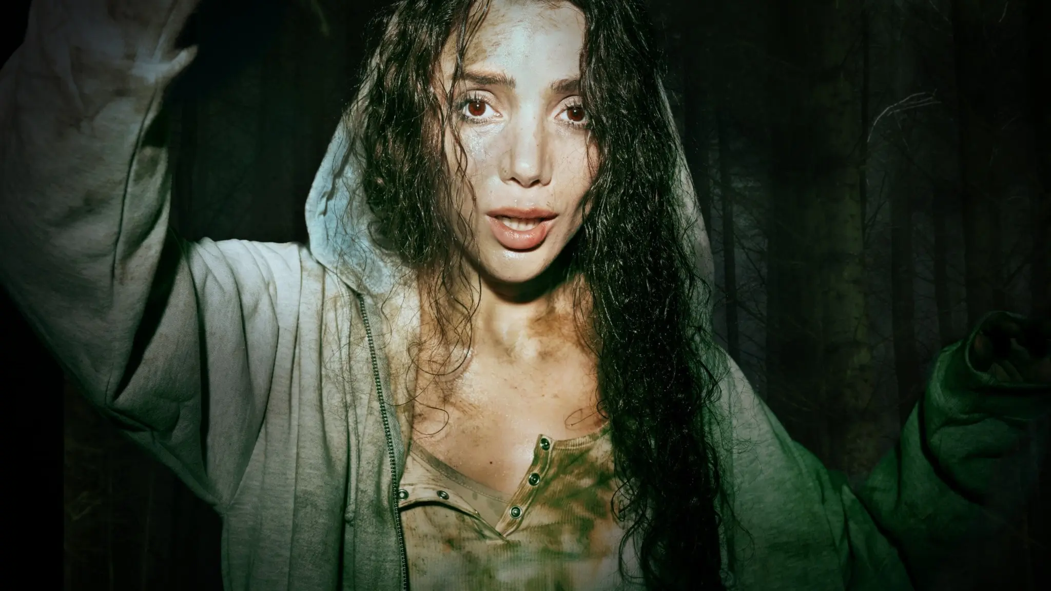 Gina Dirawi, i rollen som Lydia, tittar med skräck in i kameran. Bakom henne syns en skog.