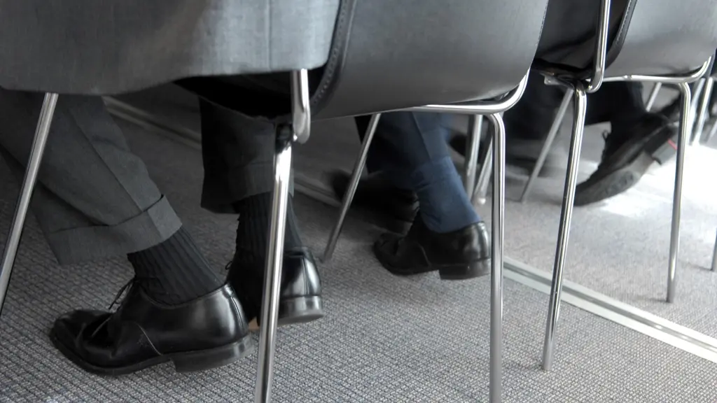 Mansben med svarta skor sitter på rad.