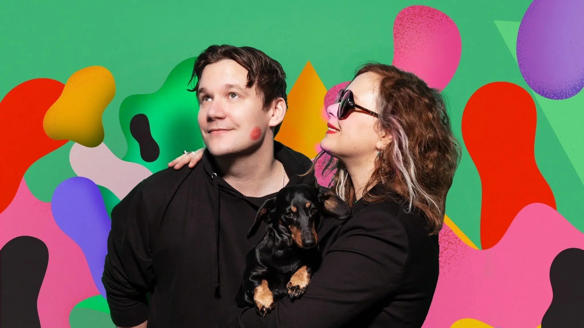 Christopher Garplind, Hanna Hellquist och taxen Ines framför grönrosa bakgrund.