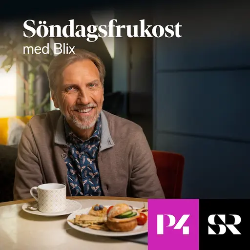 Erik Blix tittar leende in i kameran. Han sitter vid et