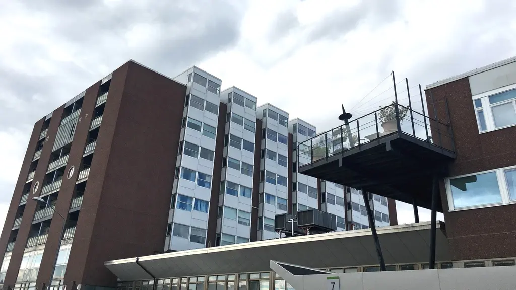 Stor sjukhusbyggnad fotograferad underifrån med moln ovan på himlen