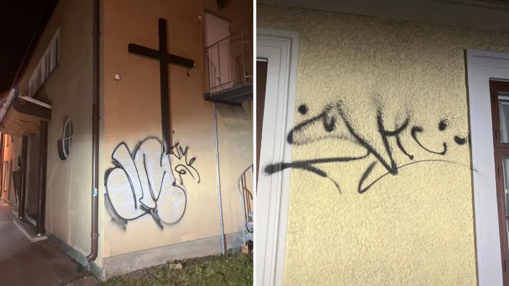 Bild som visar väggar på en byggnad med klotter och en stor svart korssymbol. Klotter består av graffiti och text på fasaden.