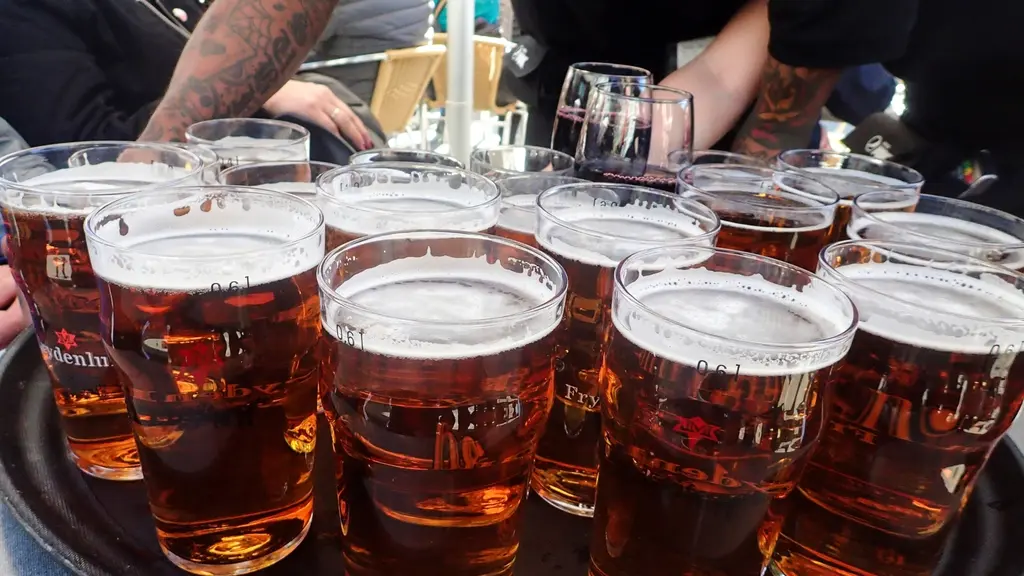 Glas med öl serveras på en bricka