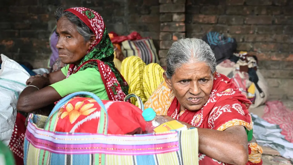 Bangladeshiska migranter vilar med väskor nära ett BSF-läger utanför Kolkata efter gränskontroll vid Indien-Bangladesh-gränsen.
