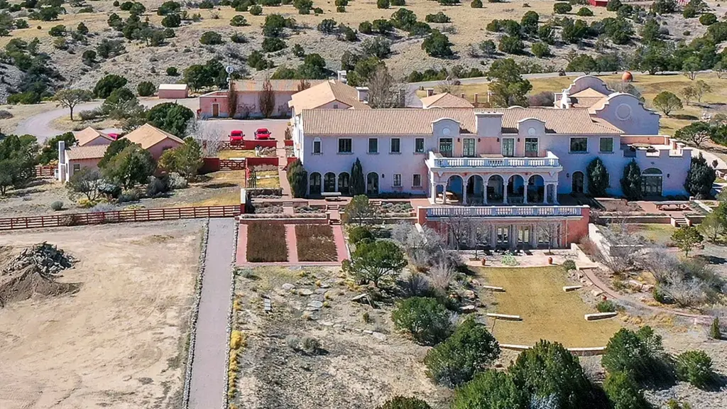 Flygbild över Zorro Ranch nära Santa Fe, New Mexico. Stora byggnader omgivna av ökenlandskap och berg i fjärran. Platsen är känd för sin koppling till den kontroversiella Jeffrey Epstein.