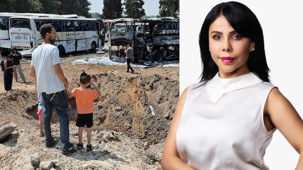 Människor står framför en enorm krater vid nedslagsplatsen för en iransk missil vid en bussdepå i Herzliya nära Tel Aviv.