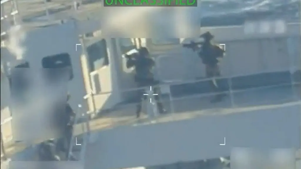 Bild visar en oljetanker till sjöss där uniformerade personer syns ombord.