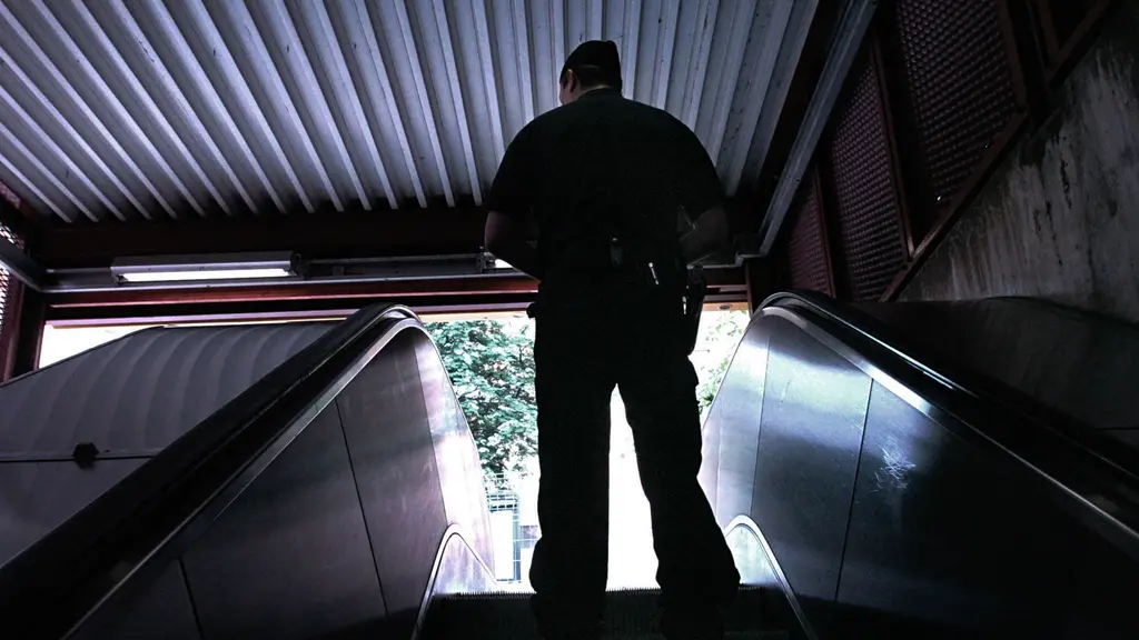 En polis i en rulltrappa i tunnelbanan.
