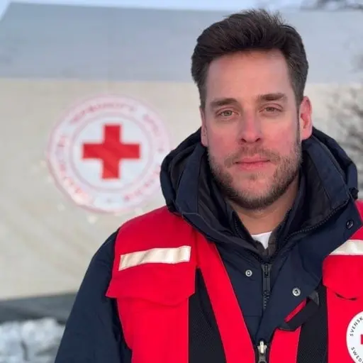 Daniel Wallinder framför ett av Röda Korsets värmetält