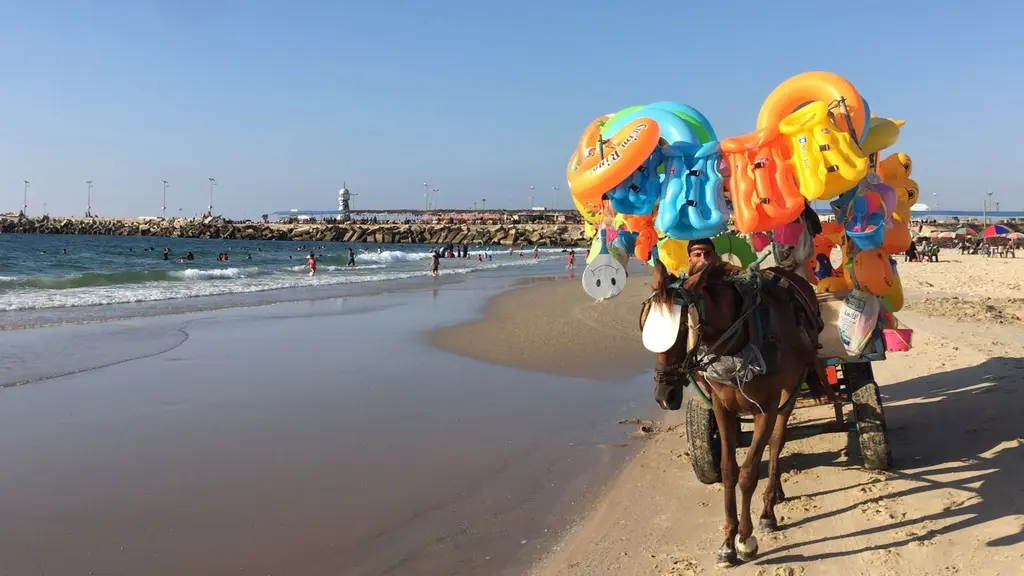 Barn leker i vattnet och badleksaker säljes på Gazas strand där föroreningarna i vattnet nått kritiska nivåer.