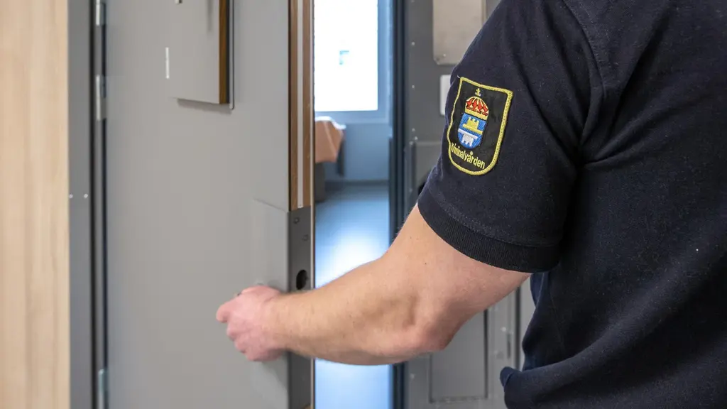 Person öppnar dörren till en cell på häkte.