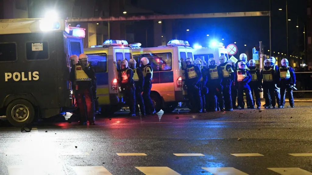 Poliser i kravallutrustning under gårdagens upplopp i Malmö.