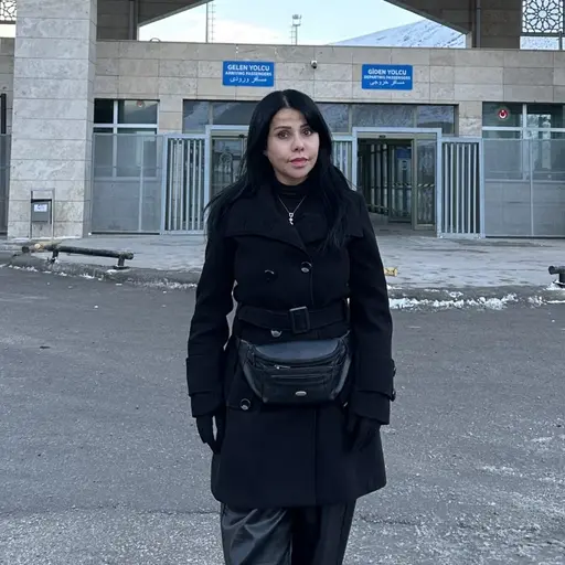 En kvinna i svarta kläder på plats vid en gränsövergång.